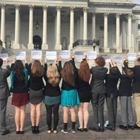 youth ambassadors standing with signs outside capitol building
