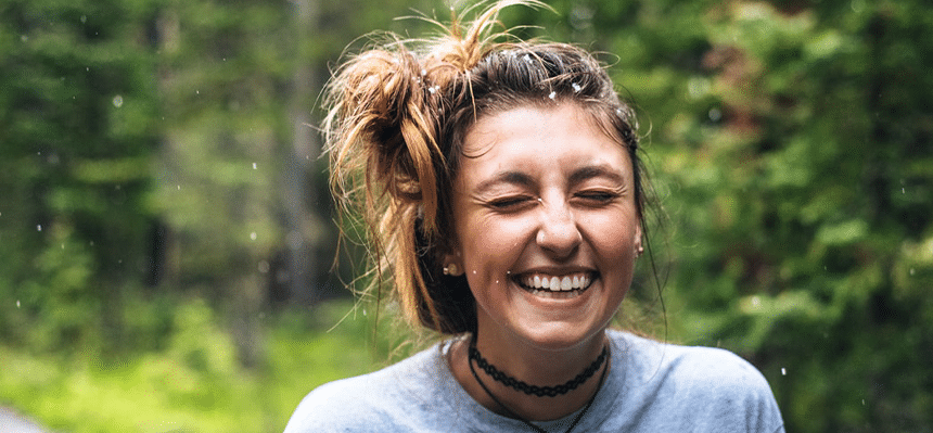 Girl smiling with woods in background